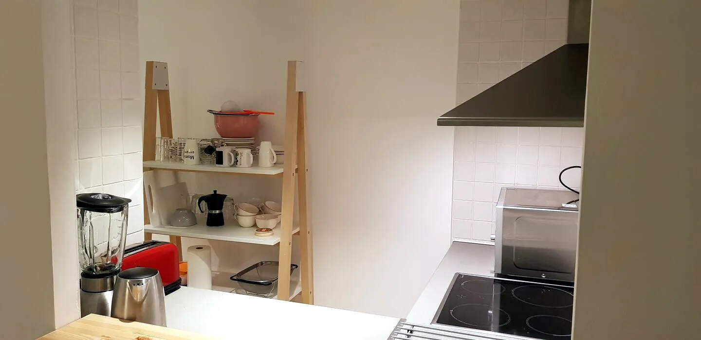 Cocina equipada con vitrocerámica, microondas, cafetera y menaje
