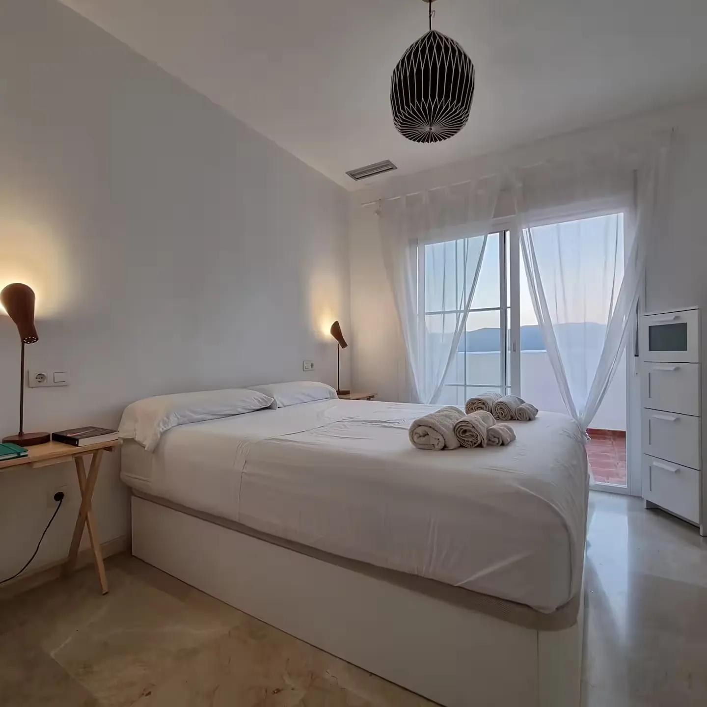Dormitorio principal con cama de 150 cm y salida a la terraza